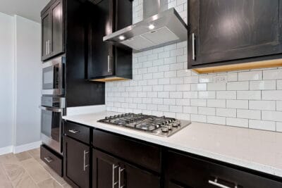 Kitchen with dark cabinets white back splash