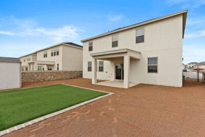 Backyard with professional landscaping and lush artificial grass in Zen floorplan move-in ready home.